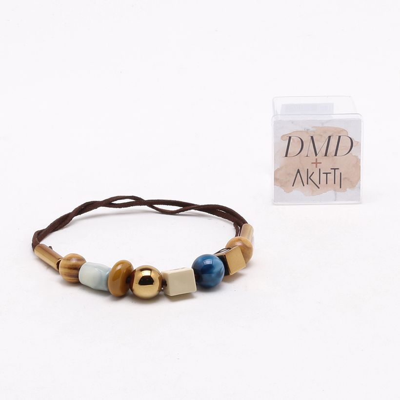 Visão do Colar DMD + Akitti na Cor Café com Várias Pedras Coloridas e sua embalagem ao fundo